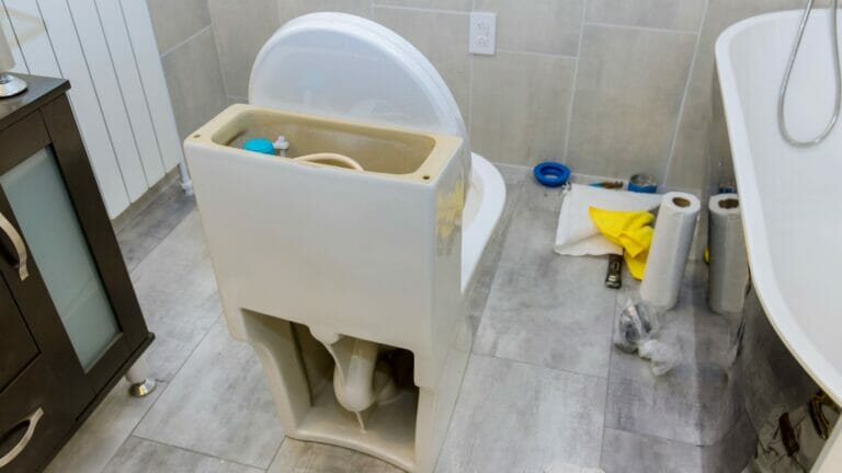 Unfinished bathroom remodel in progress, featuring repair work and new toilet installation