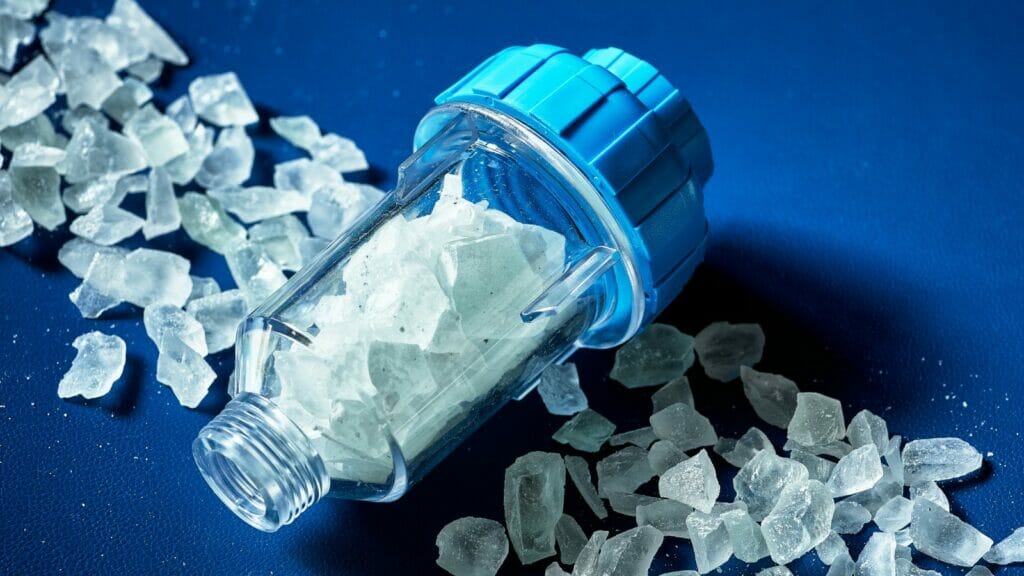 Salt crystals on a water filter system against a blue background, representing the water softening process in Rockwall, TX.