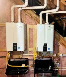Two modern Navien units mounted side-by-side in a residential attic, showcasing a professional installation ready for routine tankless water heater maintenance.