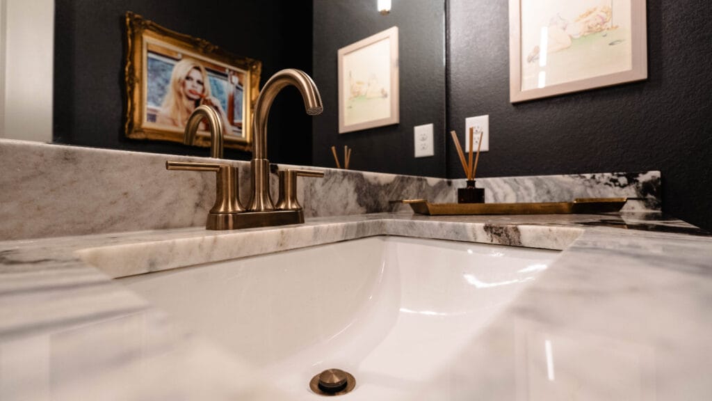 Modern bathroom sink with a marble countertop and faucet, illustrating the result of effective methods to unclog and maintain a clean sink.