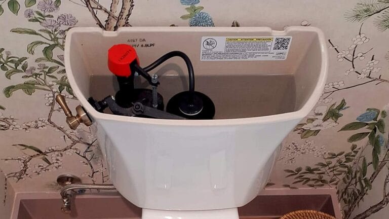 The open tank of a toilet showing the internal fill valve and flush mechanism components.