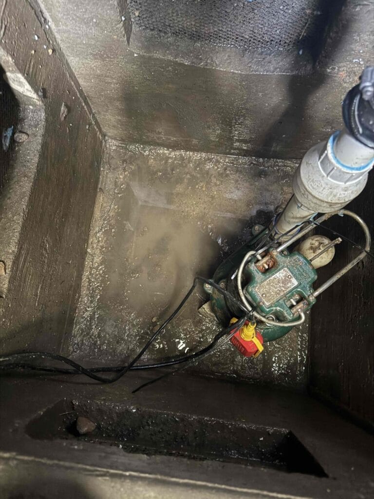 A sump pump installed inside a concrete pit in a crawl space in Royse City, Texas.