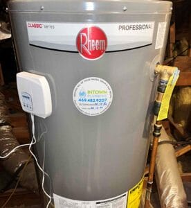 A gray Rheem Professional Classic series water heater installed by Intown Plumbing, featuring a leak detection device and a maintenance sticker with contact information.